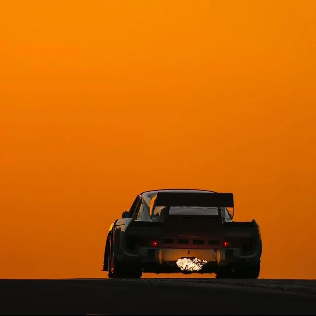 Race car silhouette against a sunset sky